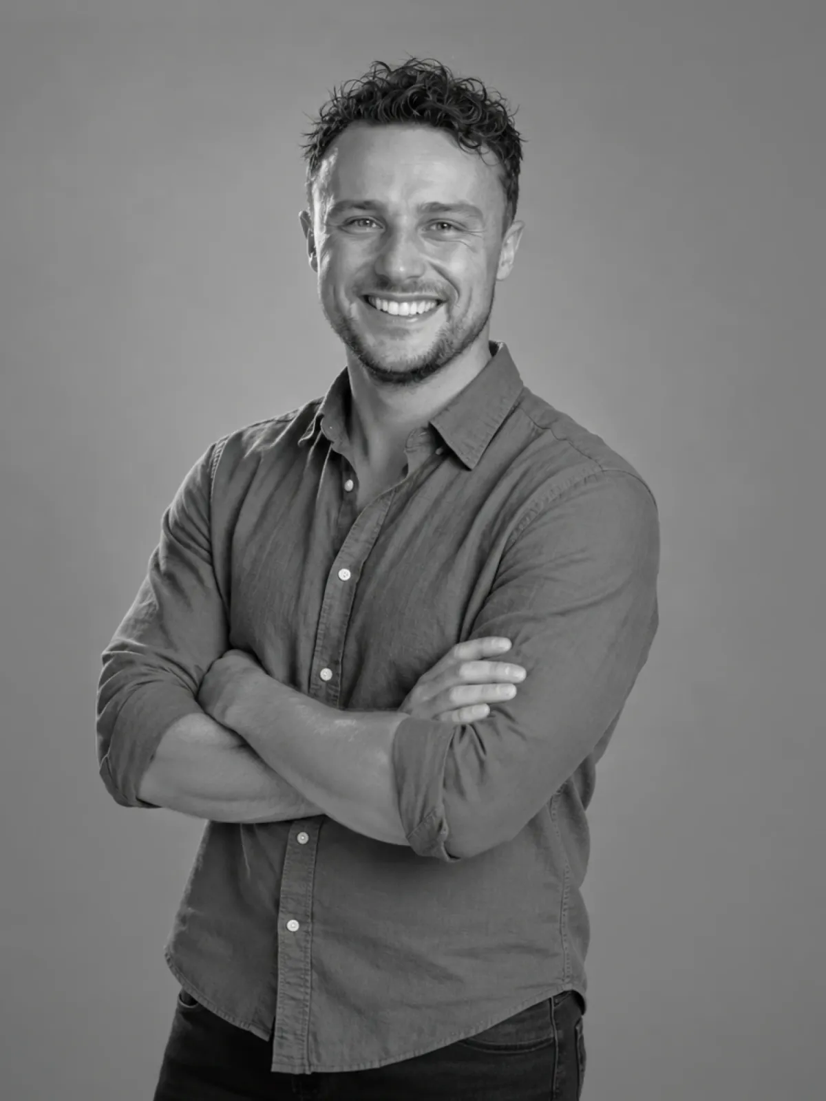 Portrait of Perry Thomas, arms crossed and smiling